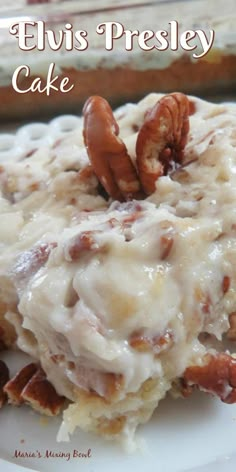 a close up of a piece of cake on a plate with nuts and icing