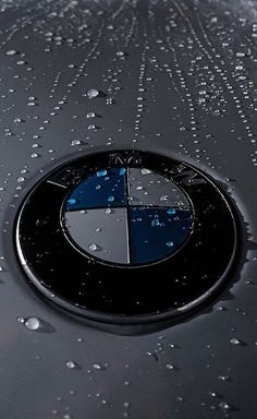 a bmw logo is shown on the hood of a car with water droplets all over it