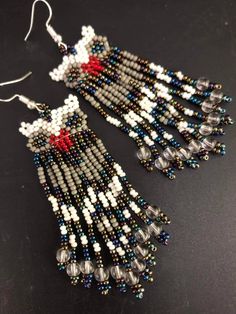 a pair of beaded earrings with red, white and blue beads hanging from them