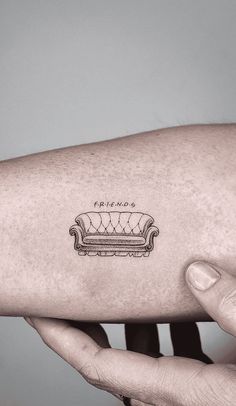 a person's arm with a couch tattoo on the left side of their arm