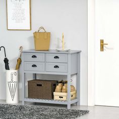 a grey table with baskets and umbrellas on it in front of a white door