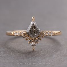 a yellow gold engagement ring with a white diamond in the center and two smaller diamonds on each side