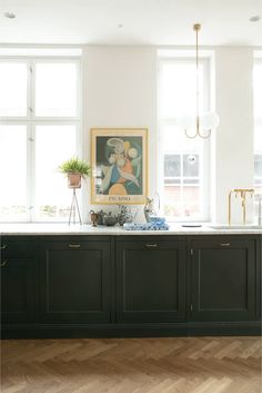 a kitchen with black cabinets and white walls