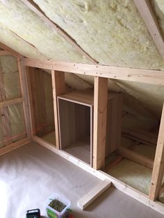 an unfinished room with wooden walls and insulation in the ceiling, some tools are on the floor