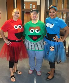 three women in costumes standing next to each other with one woman wearing an sesame character t - shirt