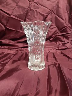 a glass vase sitting on top of a red cloth