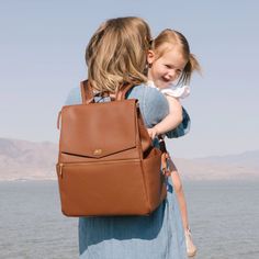 a woman carrying a brown purse over her shoulder