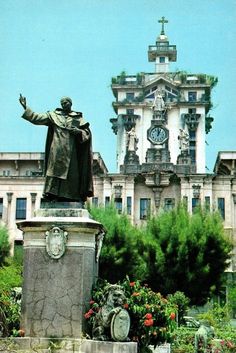 a statue in front of a building with a clock tower