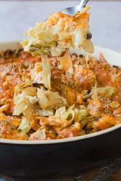 a spoon is lifting some food out of a casserole dish