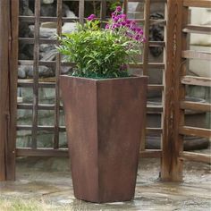 a tall planter with purple flowers in it