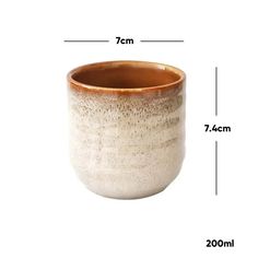 a white and brown ceramic cup with measurements