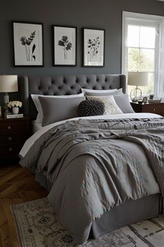 a bedroom with gray walls and bedding in the center, two framed pictures on the wall