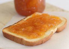 two pieces of bread with peanut butter and jelly on them sitting next to an apple