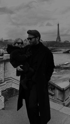 a man and woman are walking near the eiffel tower