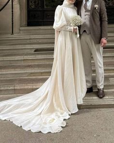 a man and woman in wedding attire standing on steps