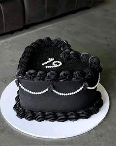 a black and white cake with pearls on it