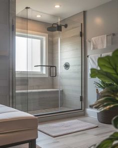 a bathroom with a walk in shower next to a bathtub and rug on the floor