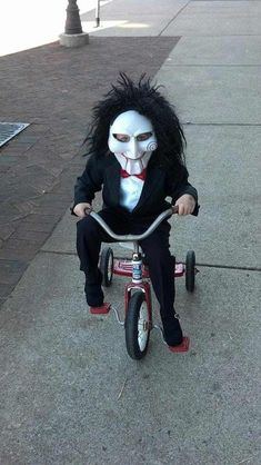 a child's tricycle with a creepy mask on it