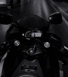 black and white photograph of motorcycle with speedometer on the handlebars at night