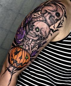 a man with a skull and pumpkin tattoo on his arm