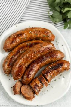 grilled sausages on a white plate with parsley