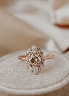 an engagement ring sitting on top of a cushion