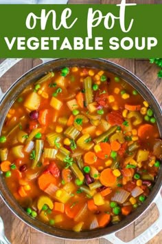 a pot filled with vegetable soup on top of a wooden table