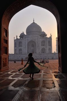 a woman is walking through an archway in front of the tajdari mosque