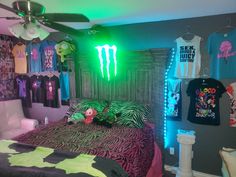 a bed room with a neatly made bed and monster shirts on the wall above it