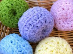 four balls of yarn sitting on top of a wicker basket next to each other