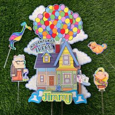 there is a house with balloons in the air and other decorations on top of it