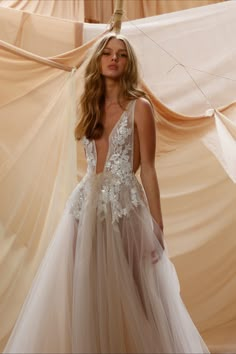 a woman in a wedding dress is posing for the camera with her back to the camera