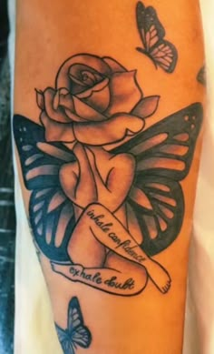 a tattoo with a rose and butterfly on the leg, which has a message written in it