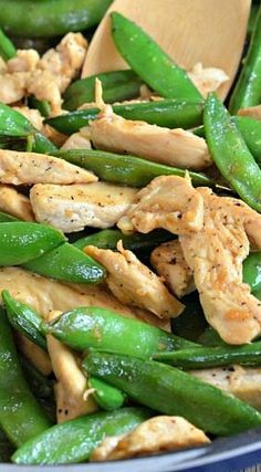 chicken and green beans in a skillet with wooden spoon