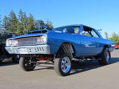 a blue muscle car parked in a parking lot