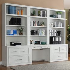 a white bookcase with many books on it in a living room next to a couch