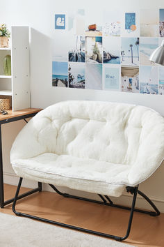 a white futon chair sitting on top of a wooden floor next to a book shelf