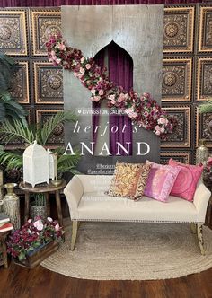 a white couch sitting on top of a wooden floor next to a wall covered in flowers