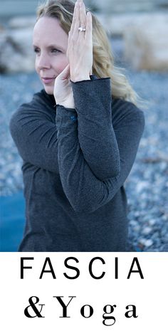 a woman with her hands up in the air while standing on top of a rock covered ground