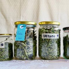 three glass jars filled with different types of herbs and labeled with price tags on them