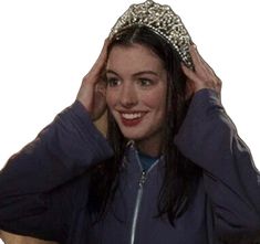 a woman wearing a tiara while holding her hair in front of her head and smiling at the camera