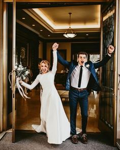 a newly married couple exiting the hotel after their wedding ceremony, holding hands in the air