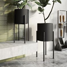 three black planters sitting next to each other in front of a wall with mirrors