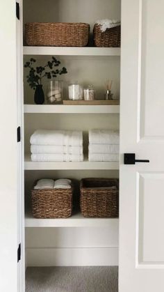 an open closet with towels and baskets in it