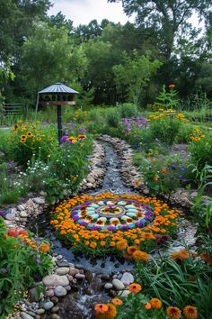 a garden with flowers, rocks and a clock on the ground in front of trees