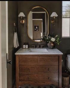 a bathroom with a sink, mirror and two lights on the side of the wall