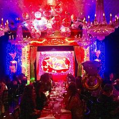 a group of people sitting at a table in front of a red and blue stage