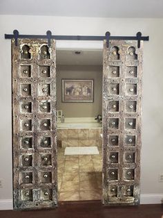 an open door leading to a bathroom with a large mirror on the wall above it