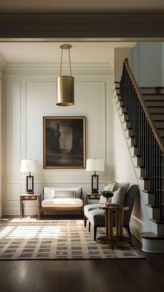 a living room filled with furniture and a stair case next to a painting on the wall