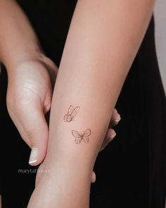 Tiny Two Butterfly Tattoo on Wrist Two Butterfly Tattoo, Butterfly Tattoo Wrist, Butterfly Tattoo On Wrist, From Caterpillar To Butterfly, Tattoo Butterflies, Nana Tattoo, Minimalist Tattoo Design, Caterpillar To Butterfly, Tiny Butterfly Tattoo